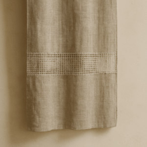 Close-up photo of a linen fabric with selective transparency against a neutral background